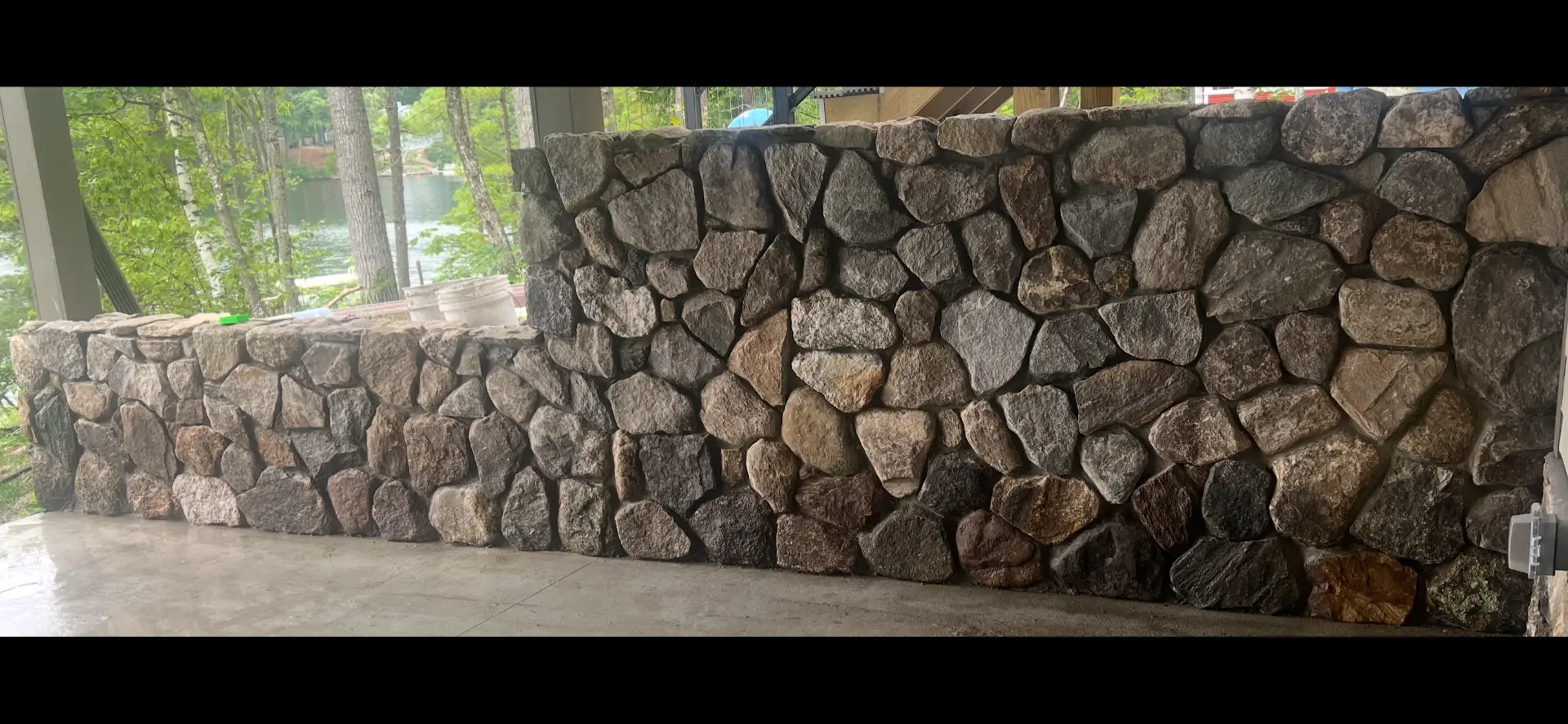Hand-built natural fieldstone wall overlooking a lake