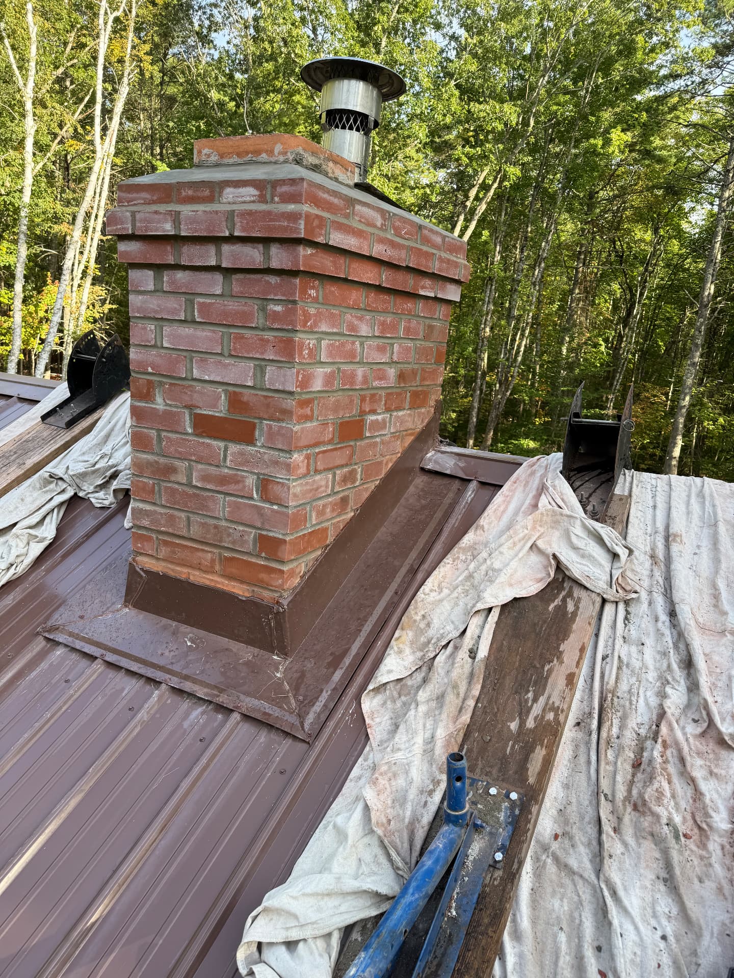 Repaired red brick chimney with new cap and roof flashing