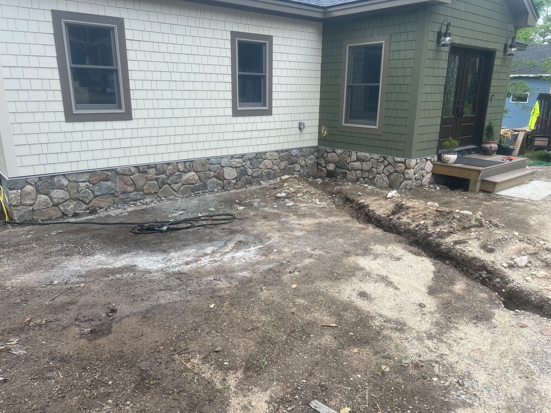 Fieldstone veneer foundation wrapping a shingled home